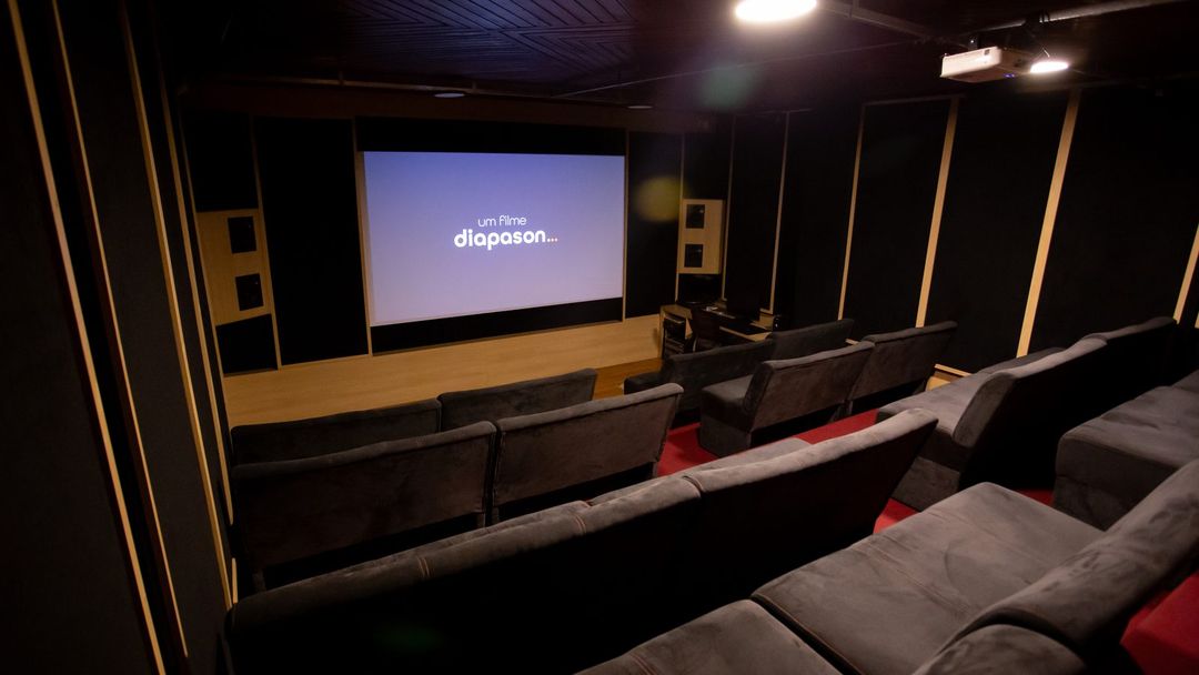 Sala de cinema do Estúdio A vista de frente, com poltronas e a tela exibindo o logo da Diapason