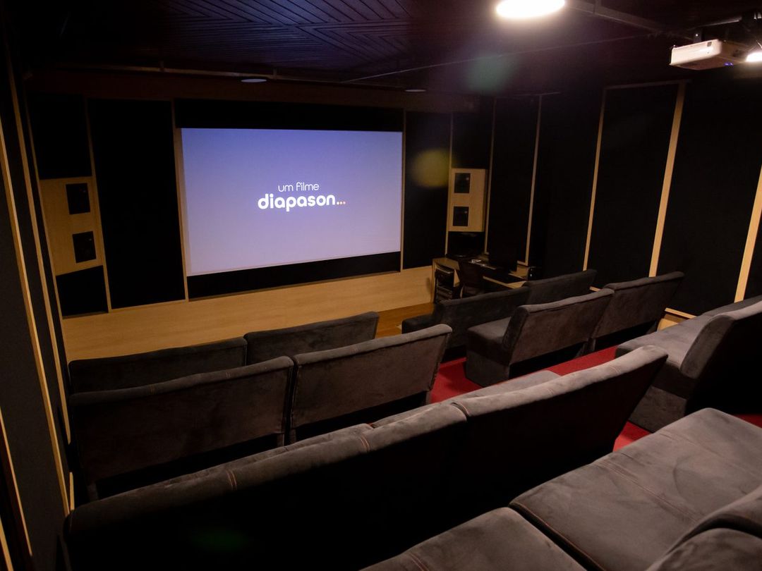 Sala de cinema do Estúdio A vista de frente, com fileiras de poltronas e a tela exibindo o logo da Diapason